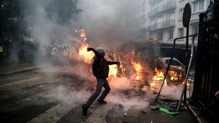 Un manifestant lance un projectile en direction des forces de l'ordre, lors d'un rassemblement des "gilets jaunes", le 1er décembre 2018 à Paris.&nbsp; (ABDULMONAM EASSA / AFP)