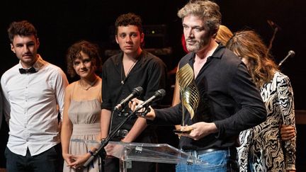 Le réalisateur français Samuel Theis reçoit le&nbsp;'Valois des etudiants francophones' pour son film "Petite Nature" à la cérémonie de clôture du 14e festival du film francophone à Angoulême, le 29 août 2021. (YOHAN BONNET / AFP)