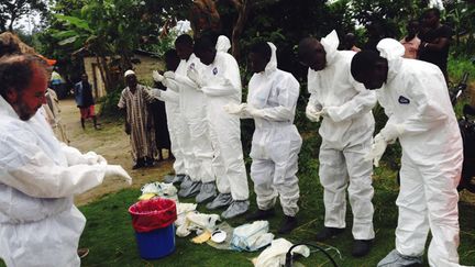 &nbsp; (Des volontaires se préparent à enterrer les corps des personnes infectées par Ebola © Reuters)