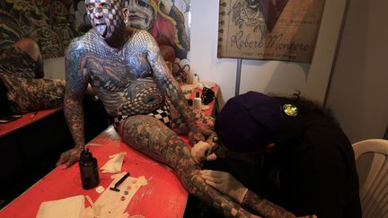 L'Am&eacute;ricain Matt Gone, dont le corps est recouvert &agrave; 98% par des tatouages se fait tatouer lors d'une convention &agrave; Bogota (Colombie), le 14 novembre 2014? (JOSE GOMEZ / REUTERS)