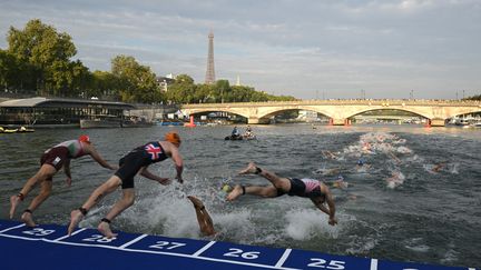 Des triathlètes plongent dans la Seine lors du test event à Paris, le 18 août 2023. (BERTRAND GUAY / AFP)