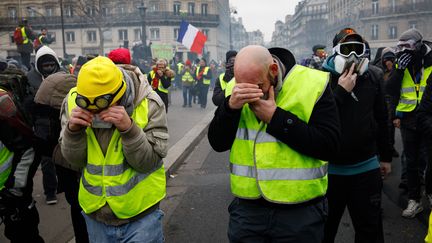 Des manifestants recoivent des tirs de gaz lacrymogènes, lors de la 8e journée de mobilisation des "gilets jaunes" à Paris, le 5 janvier 2019. (MARIE MAGNIN / HANS LUCAS / AFP)