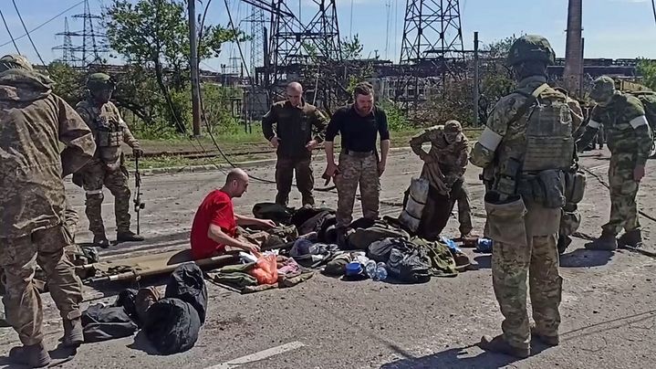 Des soldats ukrainiens, qui viennent de se rendre, sont fouillés par les soldats russes, le 17 mai 2022, selon des images fournies par Moscou. (HANDOUT / RUSSIAN DEFENCE MINISTRY / AFP)