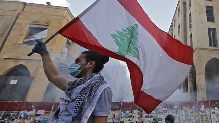 Un manifestant libanais brandissant le drapeau de son pays à Beyrouth, le lundi 10 août 2020. (JOSEPH EID / AFP)