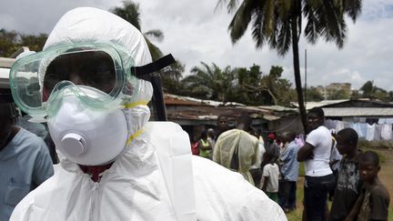 Un membre de la Croix-Rouge se pr&eacute;pare &agrave; r&eacute;cup&eacute;rer le corps d'une personne morte probablement du virus Ebola, &agrave; Monrovia (Liberia), le 4 octobre 2014. (PASCAL GUYOT / AFP)