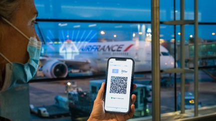 Photo d'illustration d'une femme présentant son pass sanitaire à l'aéroport de Paris-Charles-de-Gaulle, le 21 septembre 2021. (VOISIN / PHANIE / AFP)