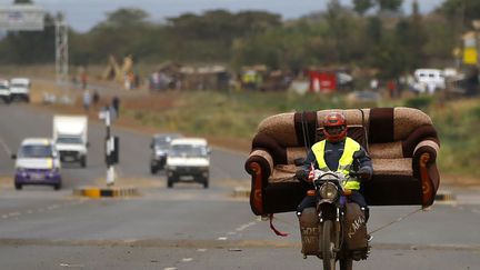 Un homme transporte un canap&eacute; sur sa moto aux environs de Nairobi (Kenya), le 10 mars 2013. (MARKO DJURICA / REUTERS)