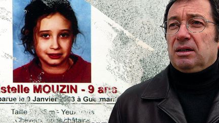 Eric Mouzin, à côté de l'avis de recherche avec la photo de sa fille, en 2003, à Guermantes (Seine-et-Marne). (MAXPPP / JESSICA KOMGUEN)