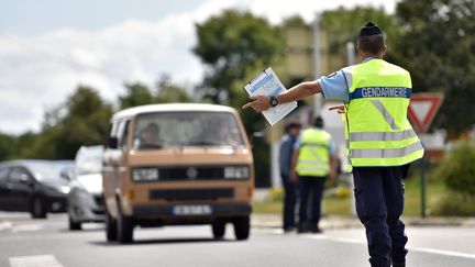 Un gendarme invite un automobiliste à se ranger sur le bas-côté, à l'entrée du festival du Bout du Monde de Crozon (Finistère), le 5 août 2016. (LOIC VENANCE / AFP)