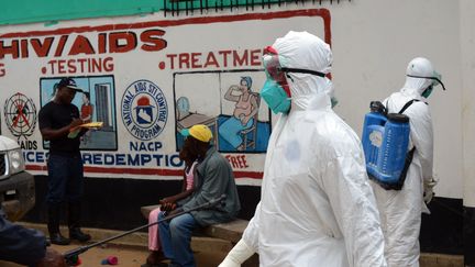 Des membres de la Croix rouge s'occupent du corps d'une victime d'Ebola, le 12 septembre 2014 au Liberia. (ZOOM DOSSO / AFP)