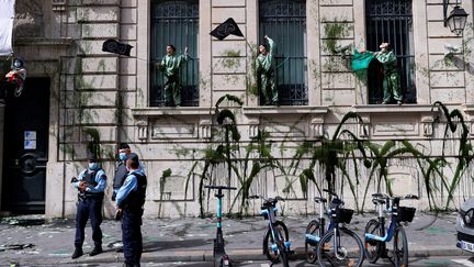 Des militants d'Extinction rebellion ont aspergée de faux pétrole la Banque de France pour dénoncer les investissements dans les combustibles fossiles, à Paris le 1er avril 2021. (THOMAS SAMSON / AFP)