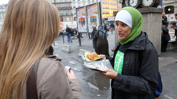 Une b&eacute;n&eacute;vole du Collectif contre l'islamophobie en France (CCIF) distribue un pain au chocolat, le 10 octobre 2012 &agrave; Paris. (THOMAS SAMSON / AFP)