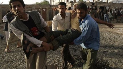 Des manifestants anti-gouvernement évacuent l'un des leurs, blessé dans des heurts, le 11 mai 2011 à Sanaa (AFP / Mohammed Huwais)