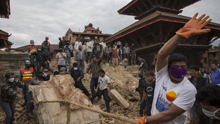 Un N&eacute;palais tentant de d&eacute;gager les ruines d'un temple, jeudi 30 avril &agrave; Katmandou (N&eacute;pal), o&ugrave; un s&eacute;isme&nbsp;a partiellement d&eacute;truit la ville. (PALANI MOHAN / IFRC / AFP)