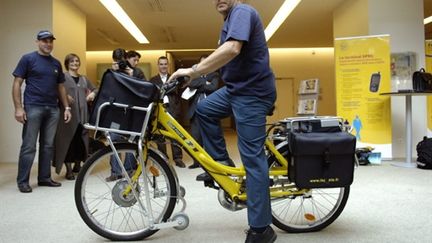 Non, la fin du facteur n'est pas forcément programmé ! Ici, un facteur essaye un vélo électrique... (AFP - STEPHANE DE SAKUTIN)