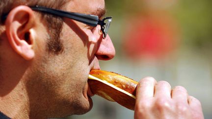 Un homme mange un sandwich au soleil pendant sa pause déjeuner. (MAXPPP)