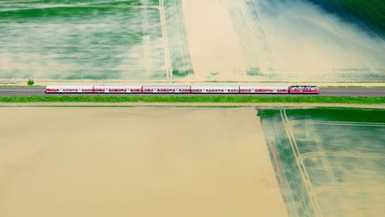 Un train traverse des paysages inond&eacute;s pr&egrave;s d'Hildesheim (Allemagne), le 28 mai 2013. (JULIAN STRATENSCHULTE / DPA / AFP)