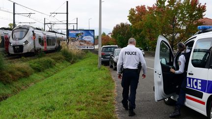 Un policier sort de son véhicule près d'un train à l'arrêt&nbsp;à hauteur de la gare de Saint-Jean-de-Luz-Ciboure après un accident qui a fait trois morts et un blessé grave, le 12 octobre 2021.&nbsp; (FRANCK LAHARRAGUE / AFP)