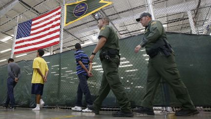 Des enfants sont escort&eacute;s mains dans le dos, &agrave; Nogales, pour aller passer des coups de fils &agrave; leurs proches. (ROSS D. FRANKLIN / AP / SIPA)