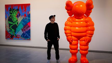 L'artiste américain Kaws devant une de ses œuvres à la Serpentine Gallery de Londres (18 janvier 2022) (TOLGA AKMEN / AFP)