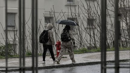 Des passants sous la pluie, le 1er avril 2023 à Lyon (Rhône). (MAXIME JEGAT / MAXPPP)