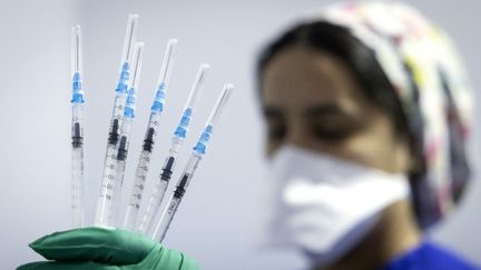Une infirmière montre des seringues de vaccin Pfizer-BioNTech dans un centre de vaccination de la ville de Salé, le 5 octobre 2021. (FADEL SENNA / AFP)