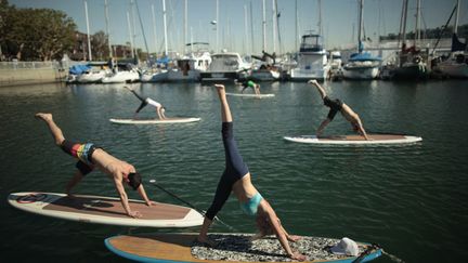 Cours de yogaqua, du yoga r&eacute;alis&eacute; sur une planche de surf pr&egrave;s de Los Angeles (Californie), le 28 janvier 2012. (LUCY NICHOLSON / REUTERS)