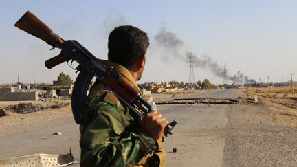 Un peshmerga kurde, observant la ville de Celavle (Irak), en passe d'&ecirc;tre reprise aux combattants de l'Etat islamique, le 24 ao&ucirc;t 2014. (FERIQ FEREC / ANADOLU AGENCY / AFP)