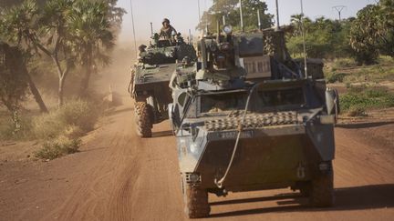 Deux véhicules blindés de l'armée française entrent dans un village lors de la patrouille Bourgou IV. (MICHELE CATTANI / AFP)