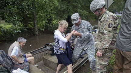 Plus de 7000 personnes ont &eacute;t&eacute; secourues en Louisiane (Etats-Unis) depuis le d&eacute;but des inondations, vendredi 12 ao&ucirc;t 2016. Cette femme a d&ucirc; emprunter une barque pour &ecirc;tre amen&eacute;e en lieu s&ucirc;r, dimanche. (MAX BECHERER / AP / SIPA)