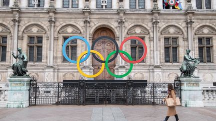 Les anneaux olympiques sont exposés devant l'hôtel de ville de Paris, le 13 mars 2023. (ALAIN JOCARD / AFP)