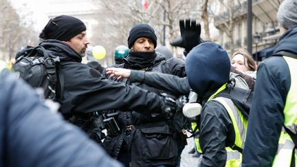 Des journalistes sont pris à partie par des "gilets jaunes", le 12 janvier 2019, près de la place de l'Etoile, à Paris. (LAURE BOYER / HANS LUCAS / AFP)