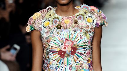 Dans notre monde contrôlé par la technologie, Rahul Mishra puise une grande gamme de couleurs dont sa nature prismatique devient l'inspiration principale. Dans sa collection intitulée "light in the sky", le faisceau de lumière attire une abeille ou un papillon sur une fleur, autant que sa couleur ou son parfum, et ceux-ci se posent sur le vêtement. Le créateur prône toujours l'artisanat indien et à ses broderies, fer de lance de la marque.
 (Bertrand GUAY / AFP)