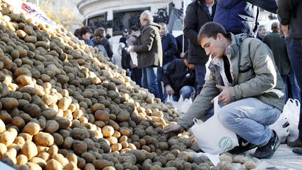 Un homme ramasse des pommes de terre d&eacute;vers&eacute;es par des agriculteurs en col&egrave;re, place de la R&eacute;publique &agrave; Paris, le 5 novembre. (THOMAS SAMSON / AFP)