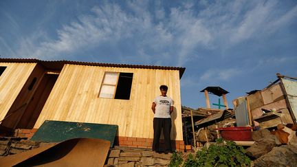 Il a vécu pendant des années dans une cabane faite de planches et de taules (à droite). Mais grâce à ses nombreux petits boulots, il a pu se construire une maison en dur.
 
 ( REUTERS / Mariana Bazo)