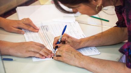 Une électrice signant le registre de vote à Paris, le 12 juin 2022.&nbsp; (MAEVA DESTOMBES / HANS LUCAS)