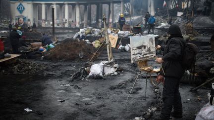 Un homme peint une sc&egrave;ne de d&eacute;solation pr&egrave;s d'une barricade &agrave; Kiev (Ukraine), le 8 f&eacute;vrier 2014. (MARTIN BUREAU / AFP)