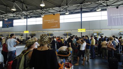 Des voyageurs s'appr&ecirc;tent &agrave; enregistrer leurs bagages, le 28 ao&ucirc;t 2005 &agrave; l'a&eacute;roport de Roissy-Charles-de-Gaullle. (STEPHANE DE SAKUTIN / AFP)