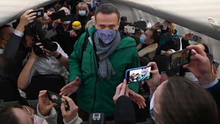 Alexeï Navalny prend place dans l'avion qui le ramène à Moscou, à l'aéroport de Berlin, le 17 janvier 2021. (KIRILL KUDRYAVTSEV / AFP)