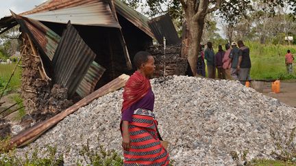 Une habitante de la&nbsp;r&eacute;gion de Lamu, sur la c&ocirc;te, marche devant une maison br&ucirc;l&eacute;e apr&egrave;s une attaque, le 6 juillet 2014. ( AFP )