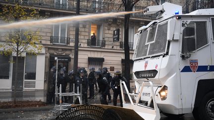 Un camion de CRS équipé d'un canon à eau tente de disperser les "gilets jaunes" près des Champs-Elysées à Paris, le samedi 1er décembre 2018. (ALAIN JOCARD / AFP)