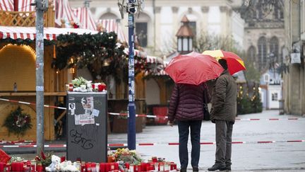 Deux passants devant le marché de Noël de Magdebourg (Allemagne), le 22 décembre 2024. (SEBASTIAN KAHNERT / DPA / AFP)