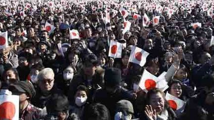 Des citoyens japonais agitent le drapeau national pendant une apparition de l'empereur Akihito et sa famille au palais impérial à Tokyo, à l'occasion du Nouvel an, le 2 janvier 2014. (Reuters - Yuya Shino)