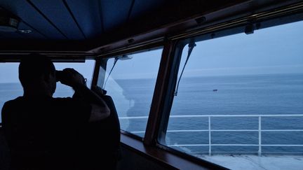 Le commandant du remorqueur d’intervention, d’assistance et de sauvetage (RIAS)  l'"Abeille Normandie" observe une embarcation de migrants avec ses jumelles (photo d'illustration, octobre 2023). (FLAVIEN GROYER / RADIO FRANCE)