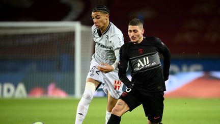 Hugo Ekitike, ici sous les couleurs du Stade de Reims, face à son nouveau coéquipier au PSG, Marco Verratti, en Ligue 1 le 23 janvier 2022. (FRANCK FIFE / AFP)