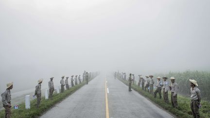 Série vie quotidienne, premier prix.&nbsp;
Dans cette série "Cuba au seuil du changement", Tomas Munita est allé photographier Cuba au lendemain de la mort de Fidel Castro. Sur cette photo, des membres de l'Armée de la jeunesse au travail attendent à l'aube le passage de la caravane transportant les cendres de Fidel Castro, le 3 décembre 2016. (TOMAS MUNITA/AP/SIPA / AP)