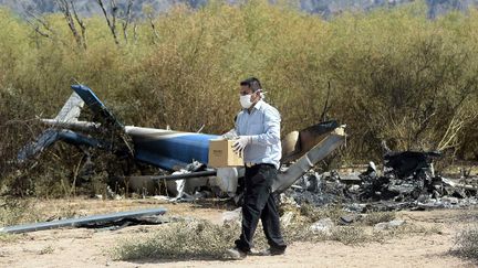 Un homme récupère des indices sur les lieux du crash de l'hélicoptère ayant coûté la vie à dix personnes dont Camille Muffat, Florence Arthaud et Alexis Vastine.