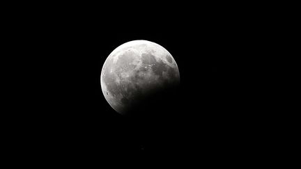 La Lune lors d'une éclipse partielle, vue depuis Koweït City, le 7 août 2017. (YASSER AL-ZAYYAT / AFP)