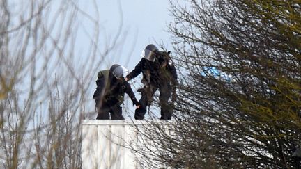 Deux policiers prennent position sur le toit de l'imprimerie de Dammartin-en-Go&euml;le (Seine-et-Marne), le 9 janvier 2015. (DOMINIQUE FAGET / AFP)