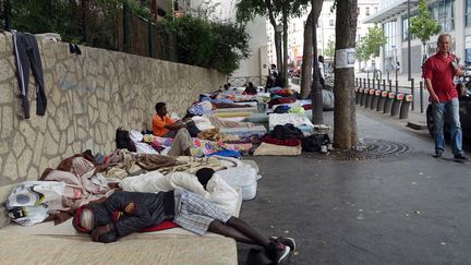 Des migrants dorment &agrave; m&ecirc;me le sol dans le quartier de La Chapelle, &agrave; Paris, le 13 juillet 2015. (GUILLEMETTE VILLEMIN / AFP)